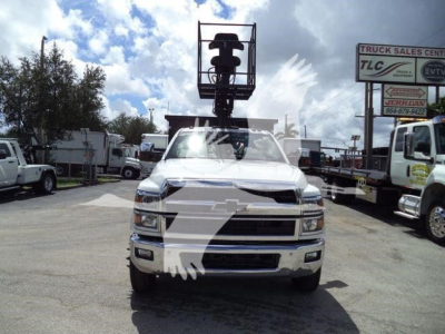 Truck front view showing Chevrolet Silverado 6500HD with equipment crane on cab and stock number 21YRDGRAPCHEV2FM in a truck lot.