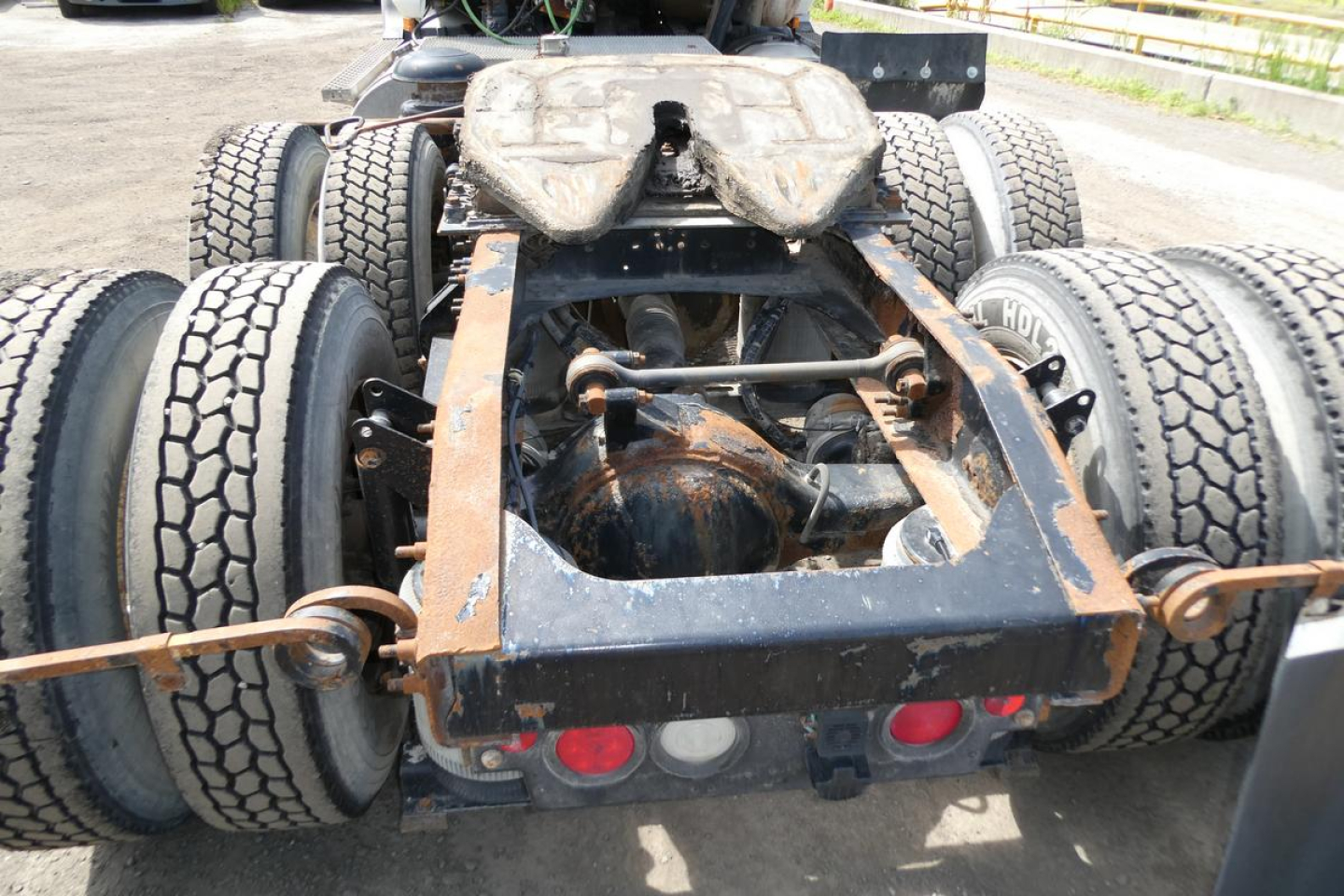 Rear view of a 2007 Mack CXN613 chassis showing dual rear axles, fifth-wheel mounting, and suspension components.