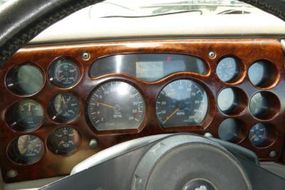 Dashboard of a Mack CXN613 truck showing multiple gauges and wood grain panel. Center gauge and digital display visible.