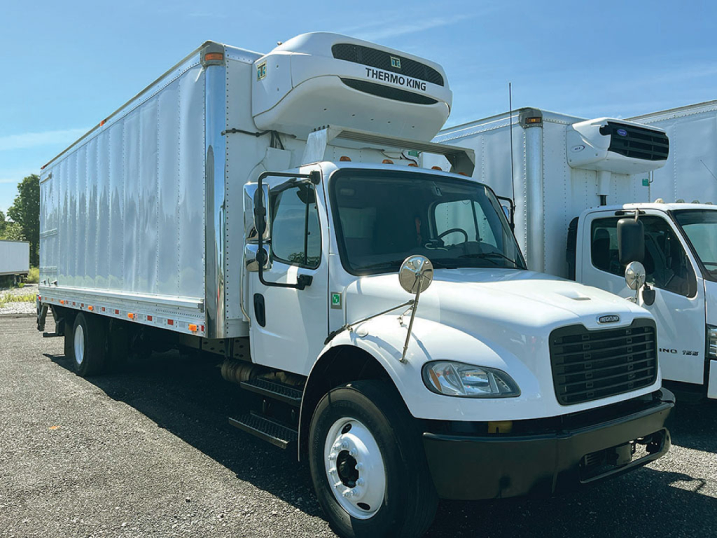 Freightliner M2 106 refrigerated truck with Thermo King unit mounted on cab, side view showing cargo box and refrigeration unit.