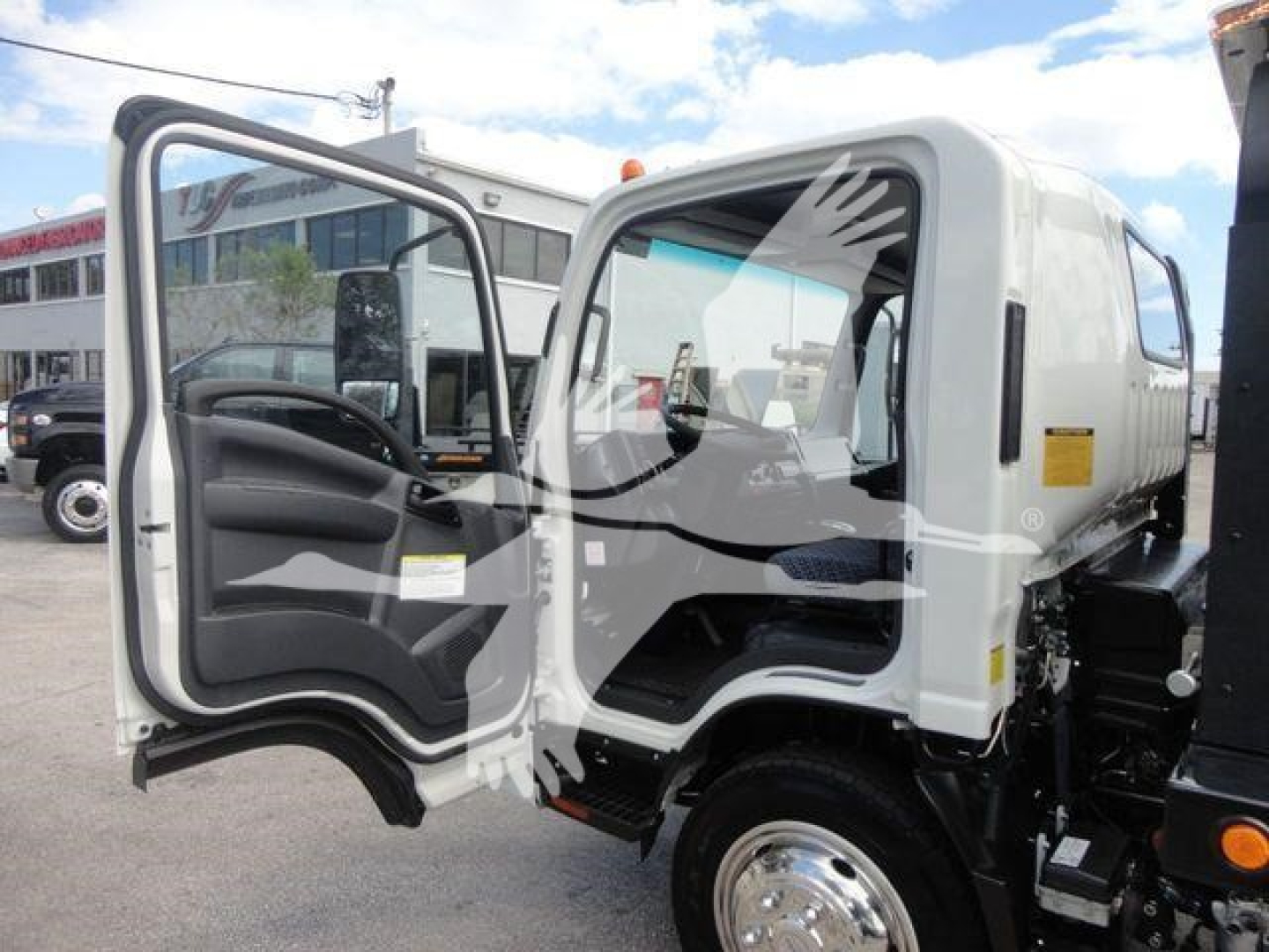 Isuzu NPR/NRR cab chassis/roll-back truck with open driver's door and step, side view showing front wheel and cabin interior.