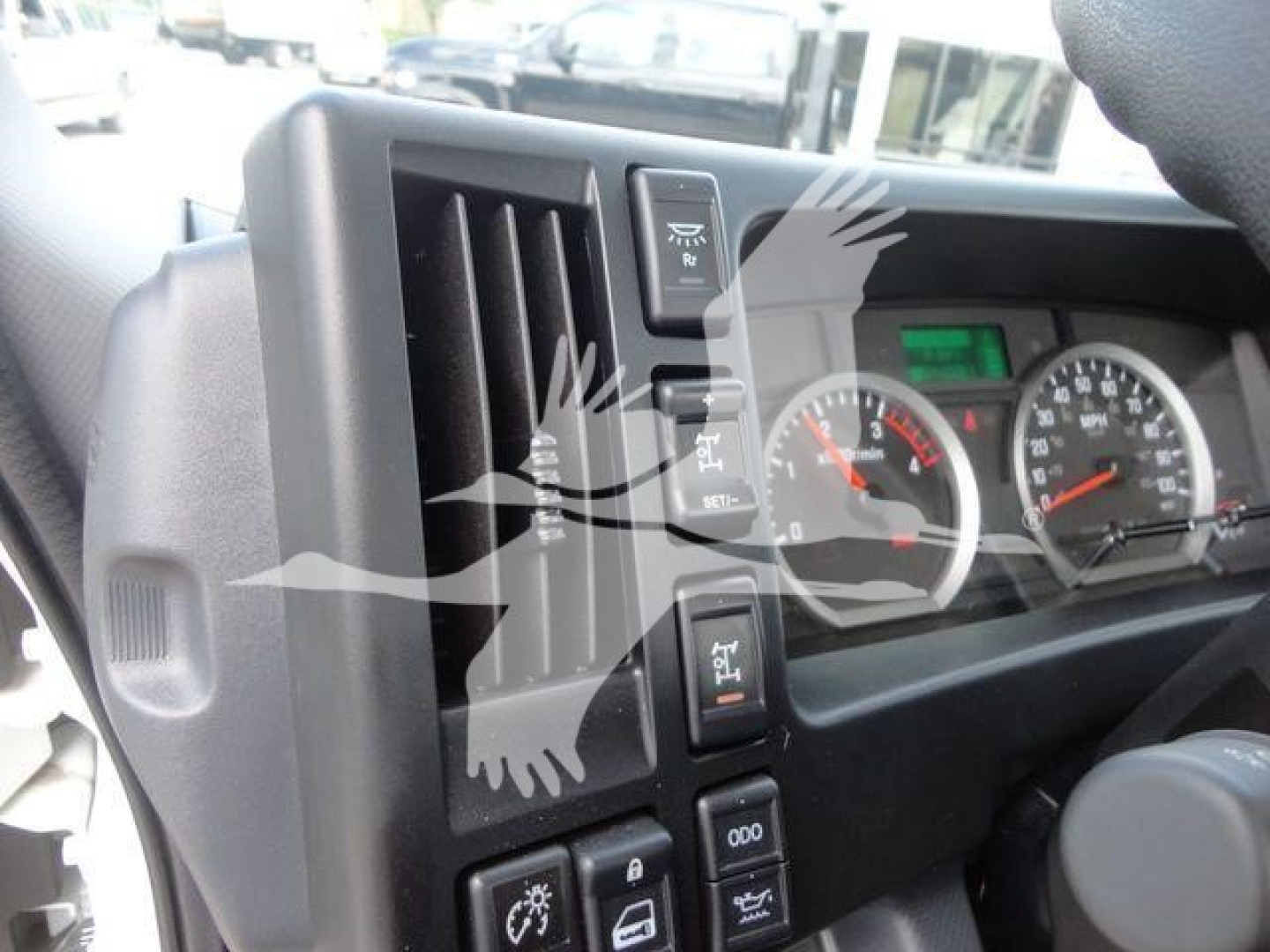 Isuzu NPRR dash area with instrument cluster and vertical control stalks visible; steering column area and vent grille seen.