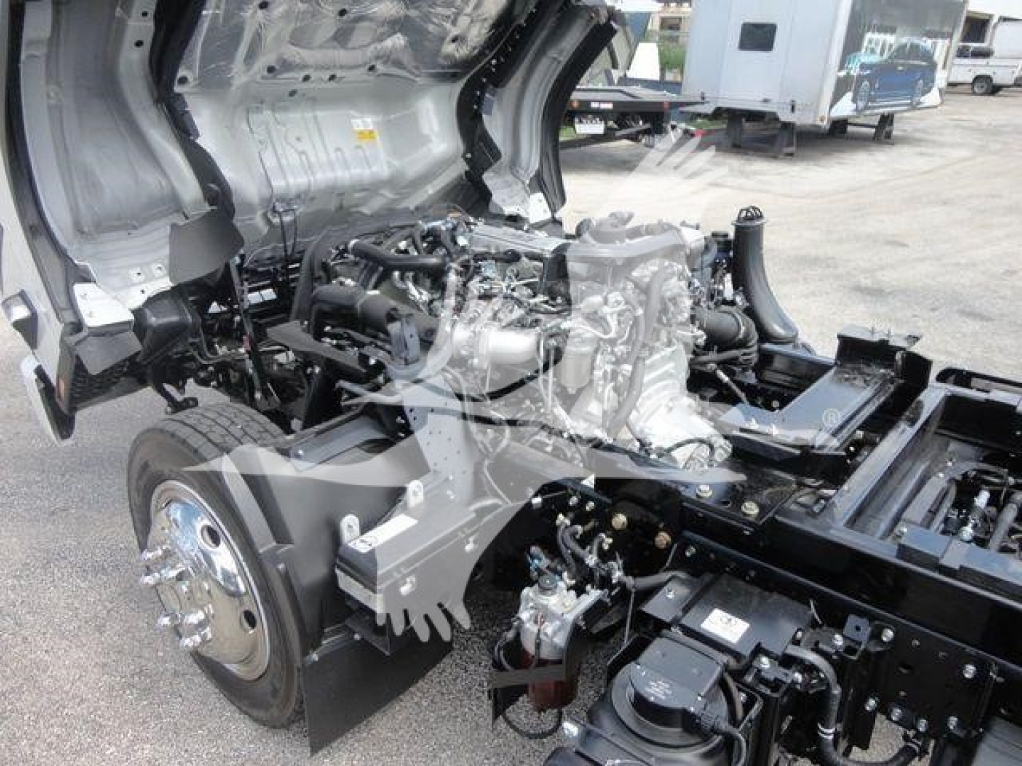 Isuzu NPR/RR truck cab off showing engine and front frame with exposed components and drivetrain.