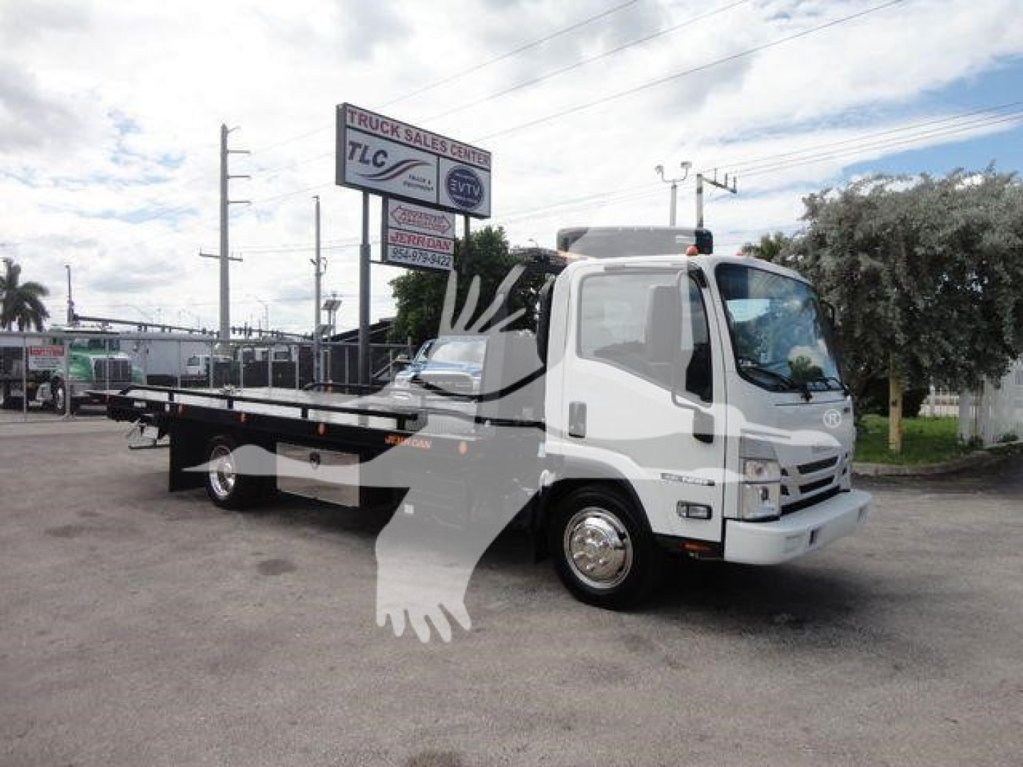 Isuzu NPR/NRR tow truck in rollback configuration showing cab and flatbed with TLC sign in background