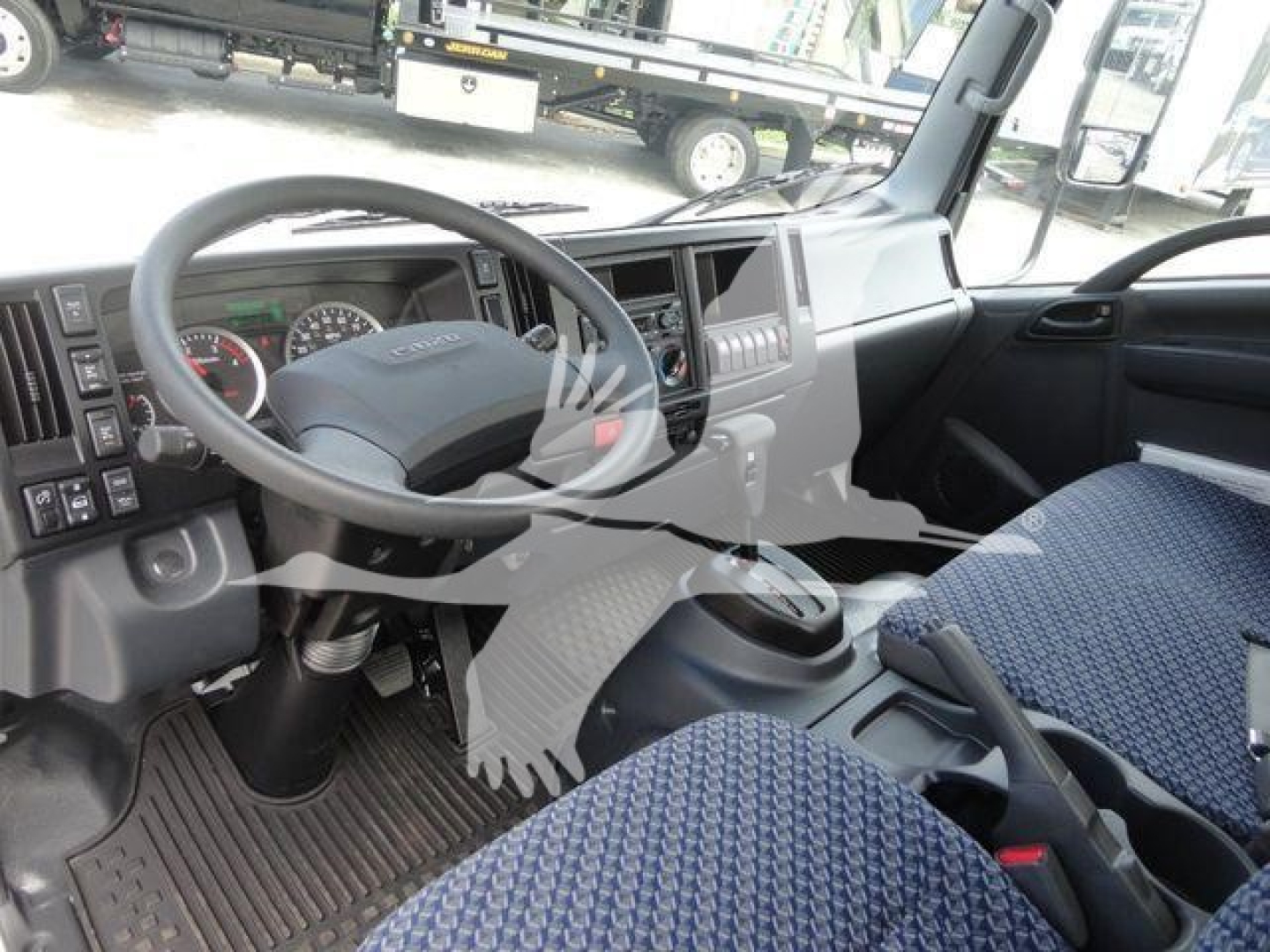 Isuzu NPR/NRR truck cab interior showing steering wheel, dashboard, and driver seat with blue fabric upholstery.