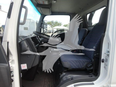 Isuzu NPR/NRR cab interior showing driver seat, passenger seat, and steering wheel inside truck cabin.
