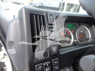 Isuzu NPRR dash area with instrument cluster and vertical control stalks visible; steering column area and vent grille seen.