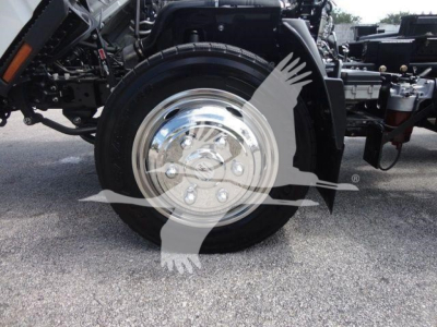 Isuzu NPR truck front wheel and chrome hubcap in view showing wheel and suspension components
