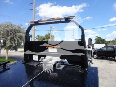 Isuzu NPR rollover truck bed withblack metal backstop and gasoline rack showing JERR-DAN branding and light bar.