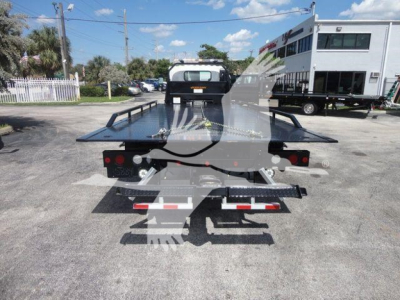 Isuzu NPRR rollback truck rear view showing flatbed with raised wheel lift and taillights.