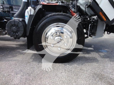 Isuzu NPR/RR rollback truck front wheel and chrome hub showing parts of chassis and hydraulic components.