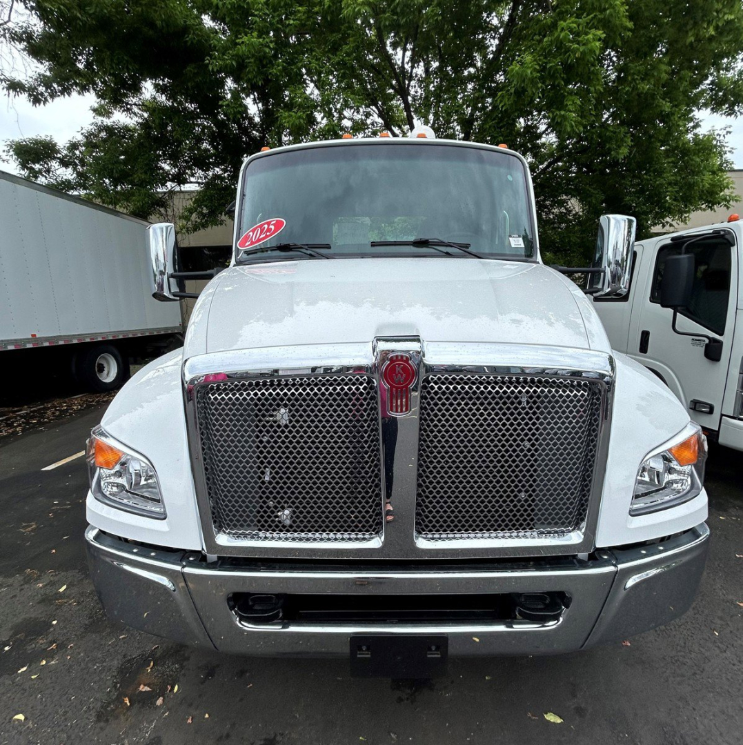 Front view of a white 2025 Kenworth T280 truck with chrome grille, dual mesh grilles, and large bumper.