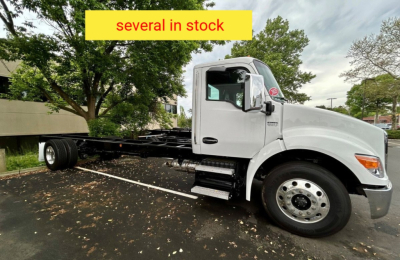 Kenworth T280 hooklift truck body showing cab and chassis with fuel tanks and wheel; text 'several in stock' banner over image.