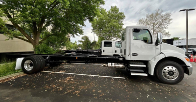 Kenworth T280 hooklift truck side view showing cab, chassis, and frame rails with front wheels. VIN 2NK3HM6X1SM135476, stock U1040, new status.