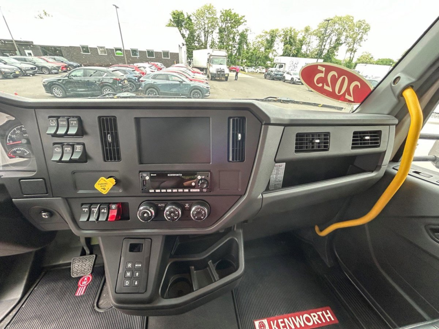 Kenworth T280 interior dashboard showing center touchscreen, controls, and gear area in new tow truck.