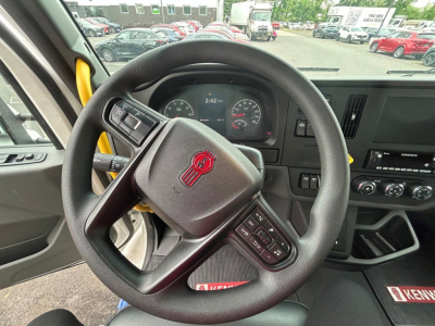 Steering wheel and dashboard of a Kenworth T280 interior showing instrument cluster and steering wheel controls.