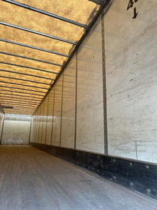 Interior of a 2014 Wabash van trailer showing wooden floor, side walls, and ceiling with ribbing.