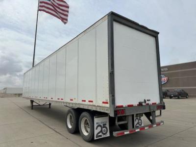 Trailer body and rear of a 2014 Wabash van trailer showing dual rear axles and empty back doors