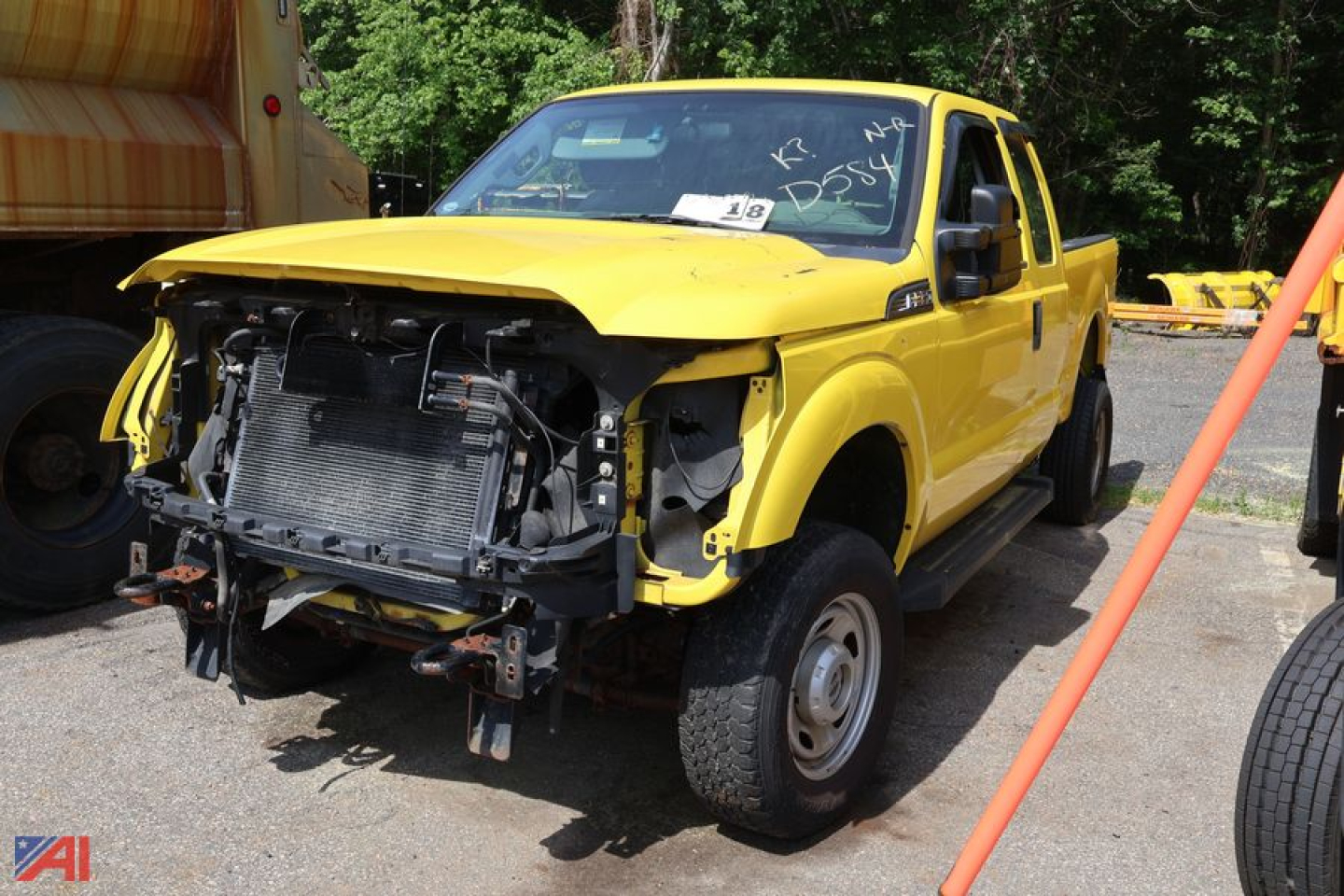 Truck front view of a yellow 2014 Ford F-250 Super Duty with hood open and damaged front end exposing radiator and components.