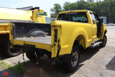Side of a yellow Ford F-250 Super Duty pickup truck with rear bed removed, showing unfinished frame and tail area.