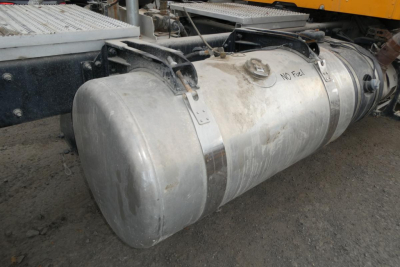 Peterbilt 567 fuel tank under a daycab tractor showing cylindrical aluminum fuel tank with mounting straps