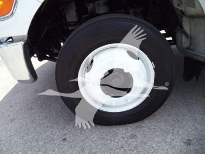 Vehicle wheel close-up showing a white hub and black tire, part of Versalift VST40i crane equipment in use.