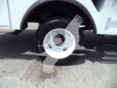 Versalift VST40i crane vehicle wheel and fender showing wheel, tire, and step plate in service condition.