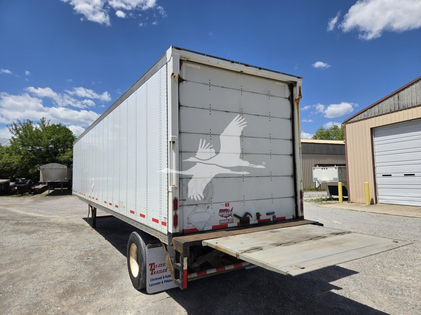 Rear 2014 Wabash van trailer with hydraulic ramp at back, white exterior, silhouette bird graphic on rear doors, stock number 7668 not visible in text