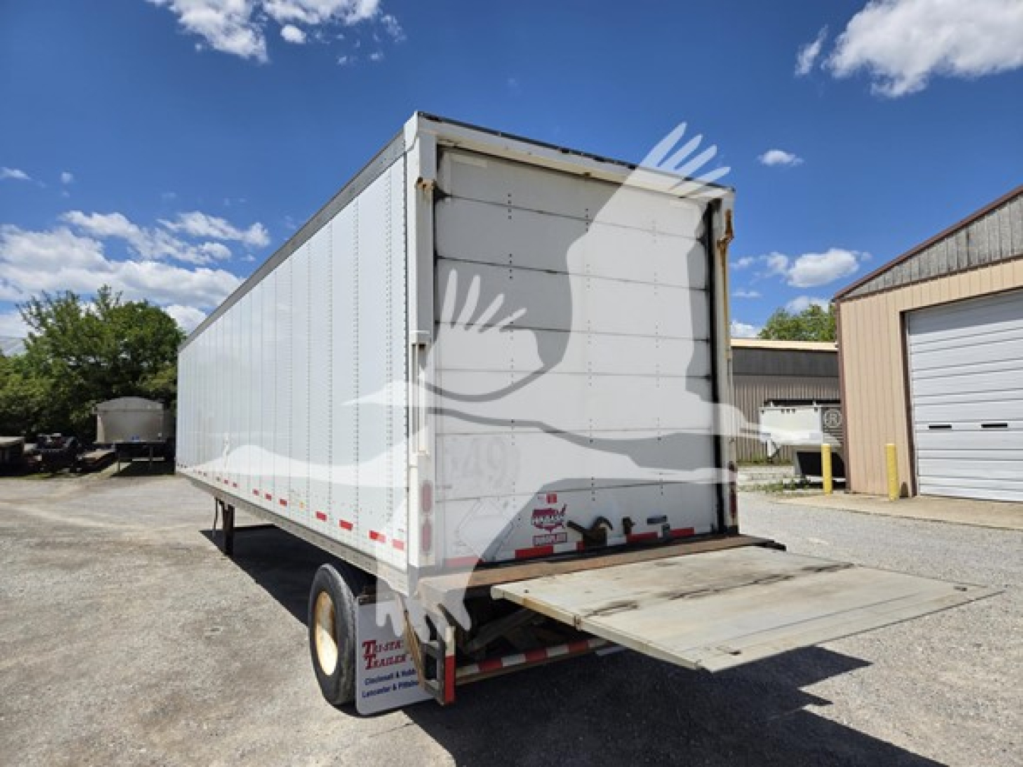 Rear view of a white 2014 Wabash van trailer with a lowered ramp/door at the back, showing the undercarriage and back of trailer.