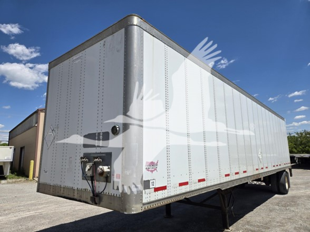 Wabash 2014 van trailer showing side view with front tongue and support legs. Exterior riveted aluminum panels, reflective tape along lower edge, rear axle and wheels visible.