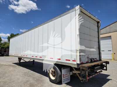 Trailer side and rear view of a 2014 Wabash van trailer showing white exterior, swinging rear doors, and a single rear axle with a long rectangular body.