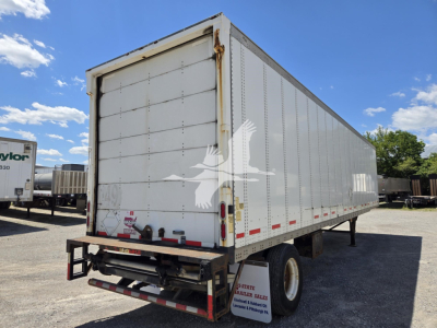 Trailer side and rear of a 2014 Wabash van trailer showing box shape, white exterior, rear doors, and red reflective stripes.