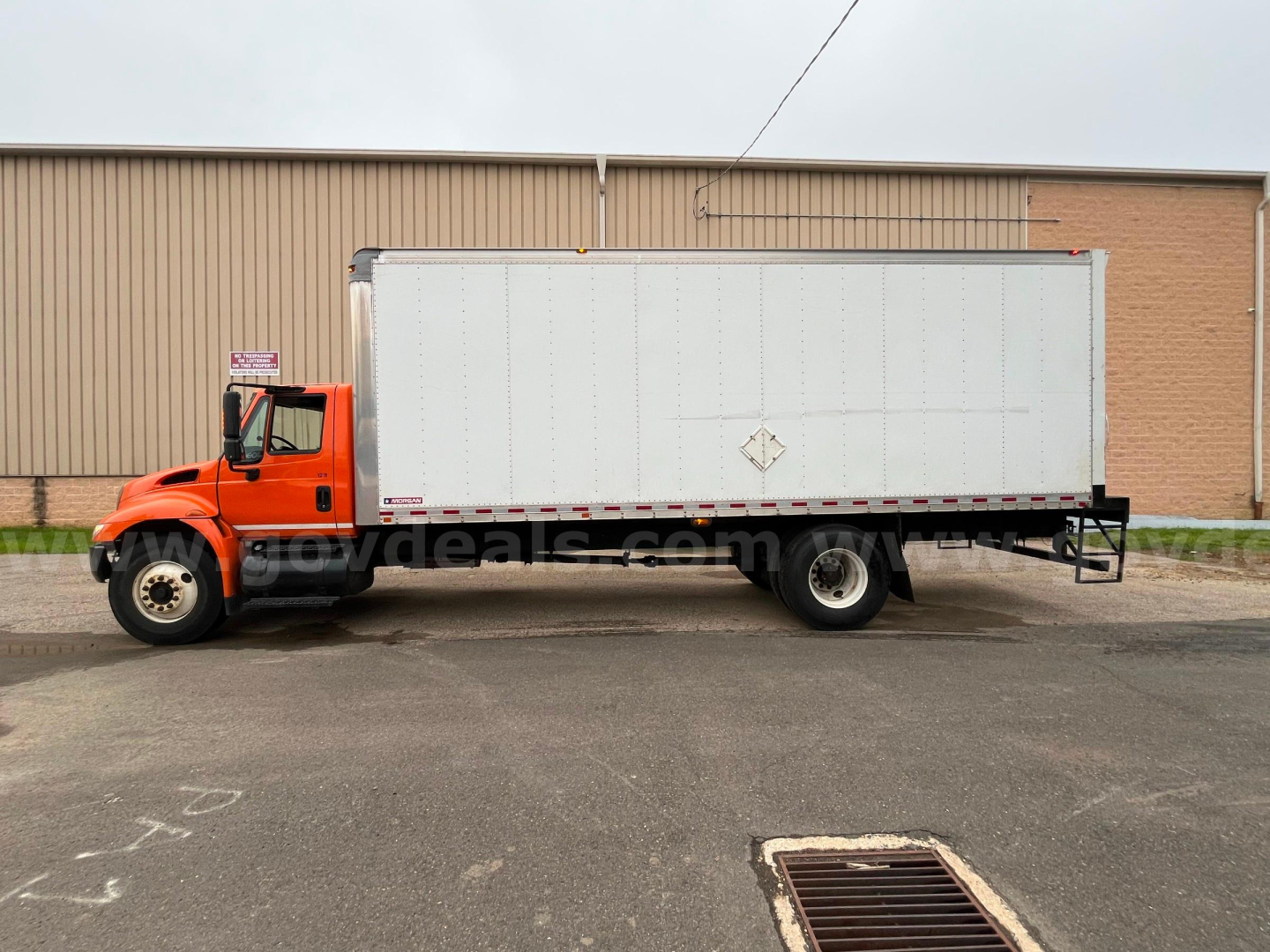 2004 International 4300 SBA box truck side view with orange cab and white box.
