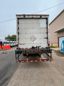 Back view of a 2004 International 4300SBA box truck showing rear doors and bumper with warning decals.