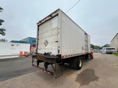 Box truck rear view showing cargo trailer with diamond placard and taillights.