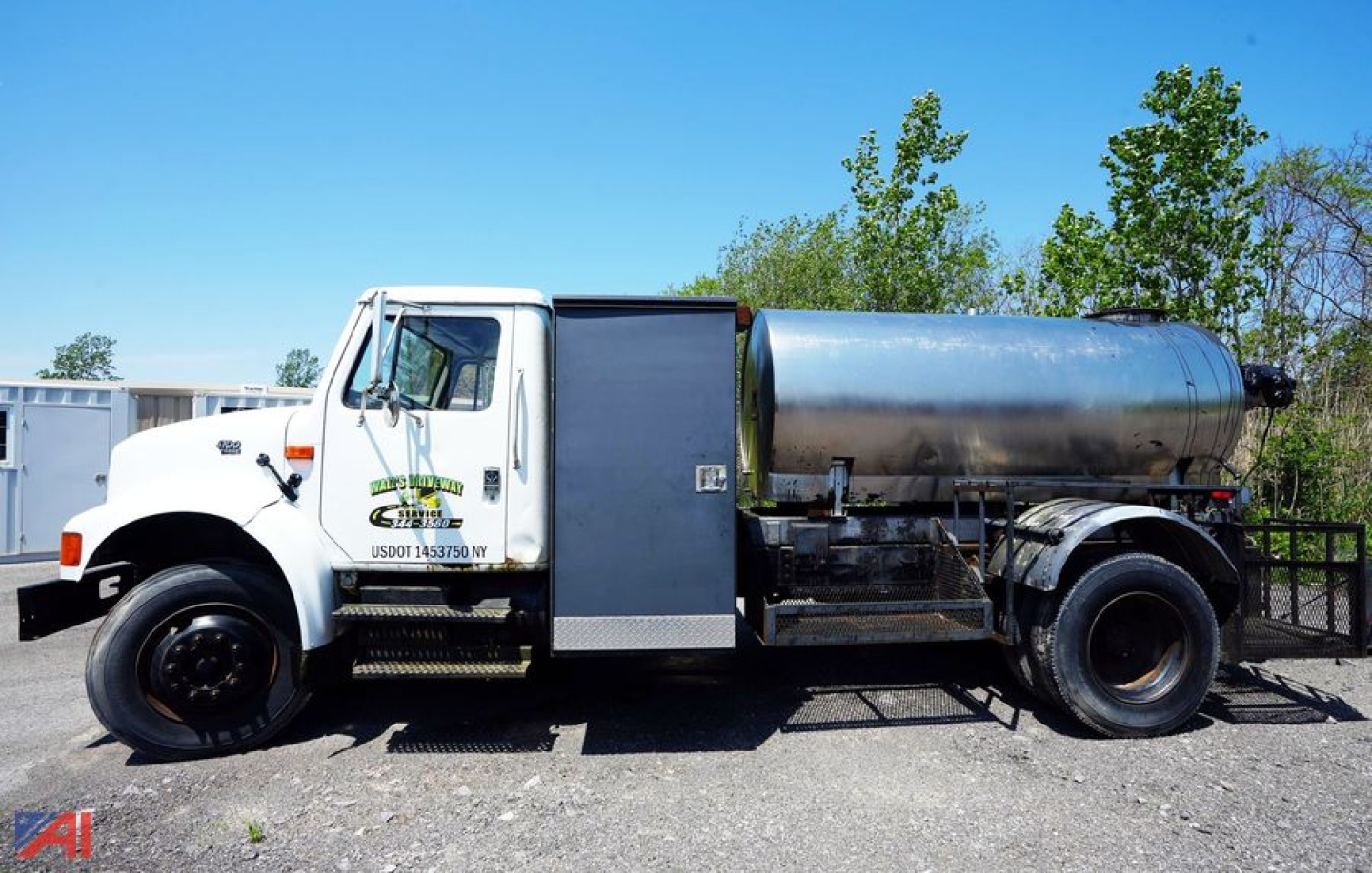 White International 4700 truck with a large cylindrical tank mounted on frame, side steps, and rear dual wheels; used truck for asphalt hot oil sealer.