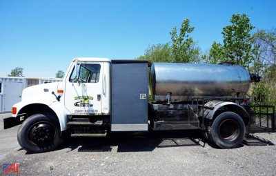 White International 4700 truck with a large cylindrical tank mounted on frame, side steps, and rear dual wheels; used truck for asphalt hot oil sealer.