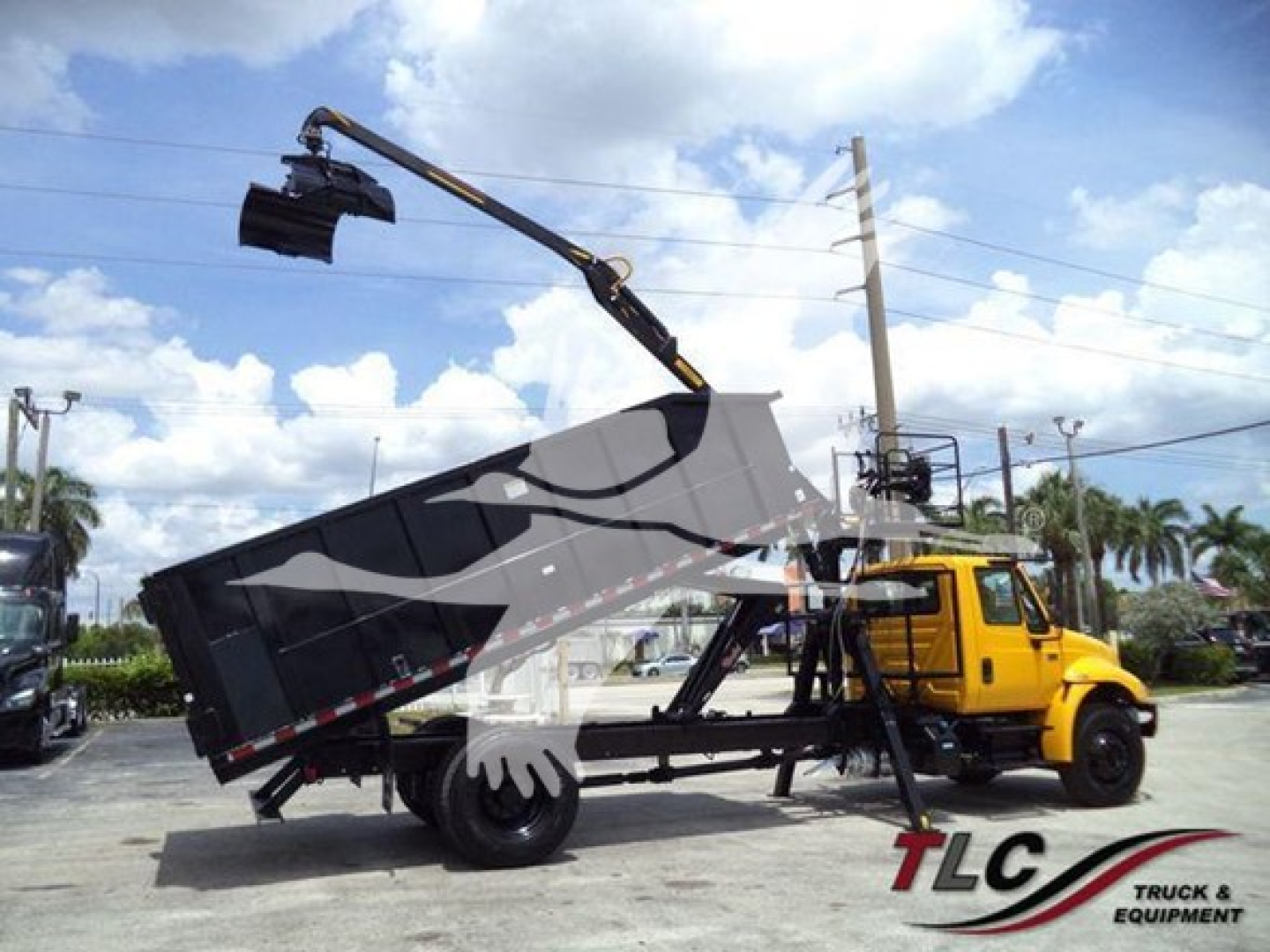 2019 International Durastar 4300 truck with a mounted hydraulic grapple and crane in a service yard.
