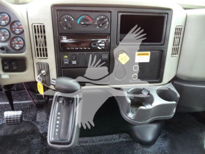Dashboard area of a 2019 International Durastar 4300 with gear shifter, climate controls, radio, and storage cup holders visible.