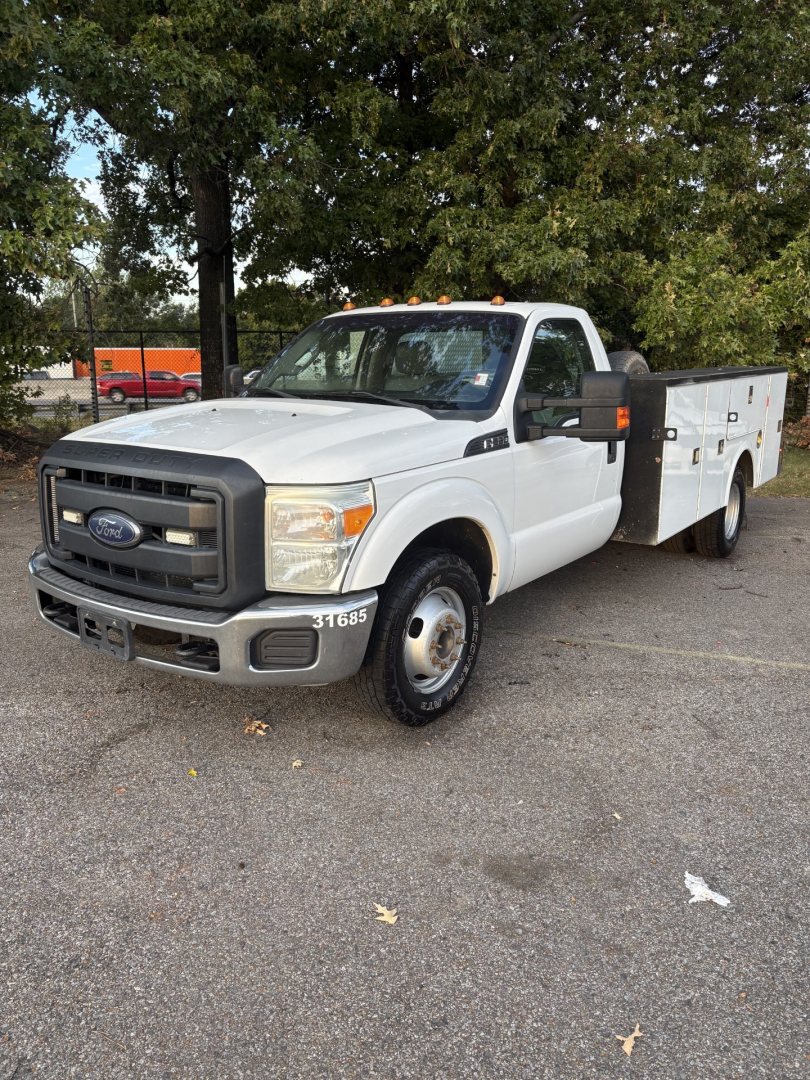 Ford F-350 cab and chassis white truck showing front grille and utility bed with compartments.