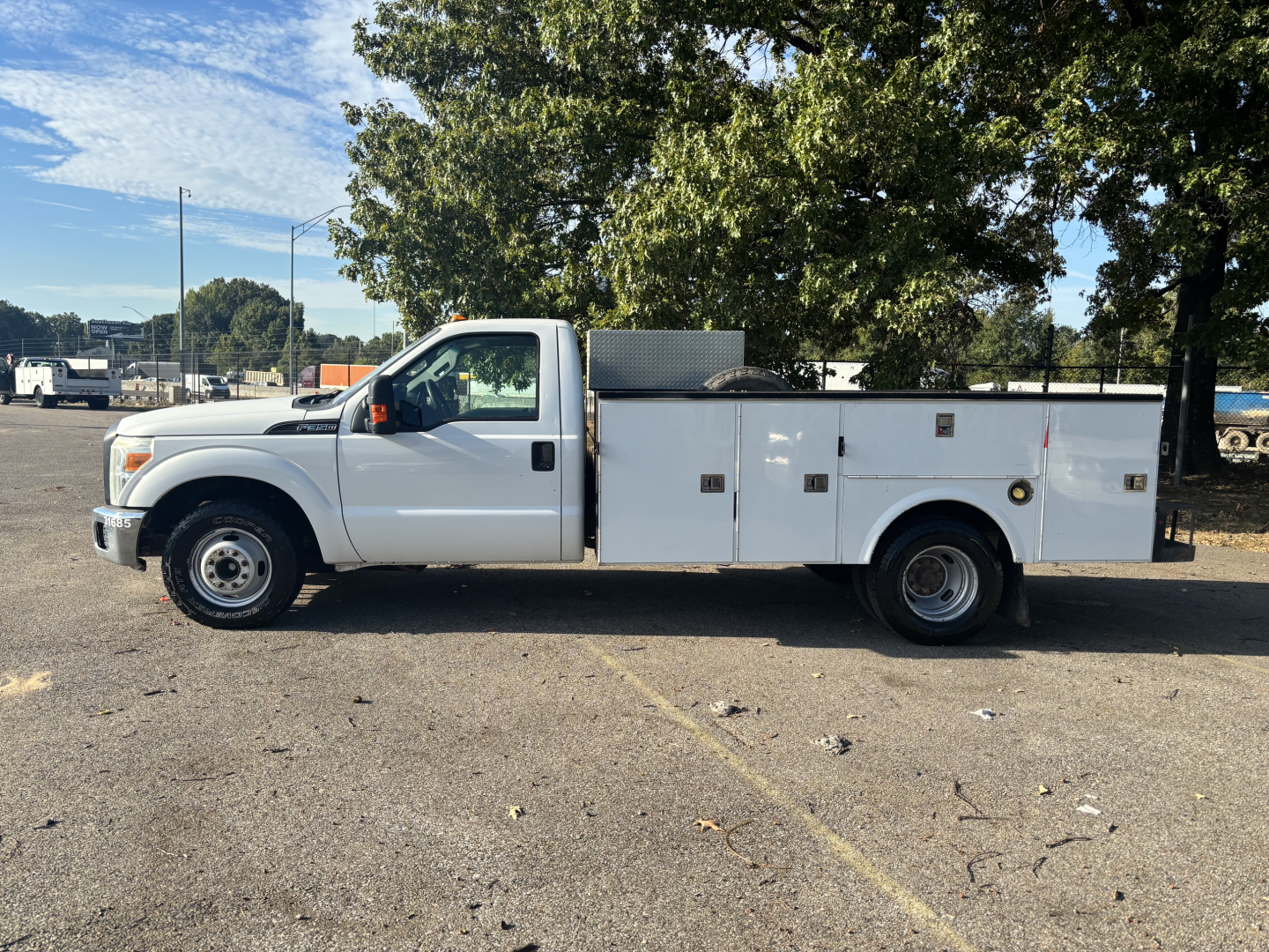 Ford F-350 cab and chassis utility body truck side view showing long utility bed compartments.