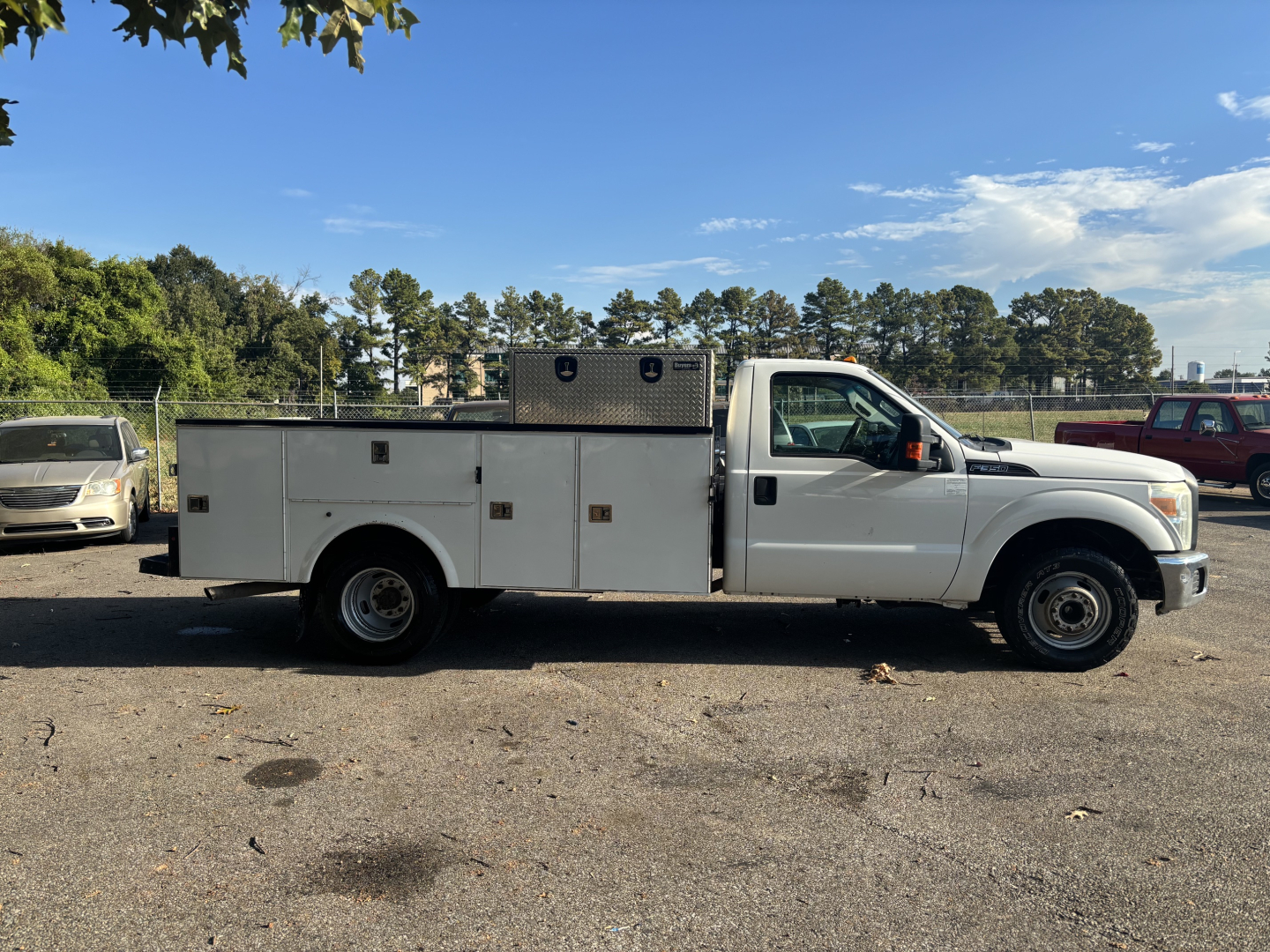 Ford F-350 utility/service truck side view showing service body with diamond storage compartments and overhead toolbox.