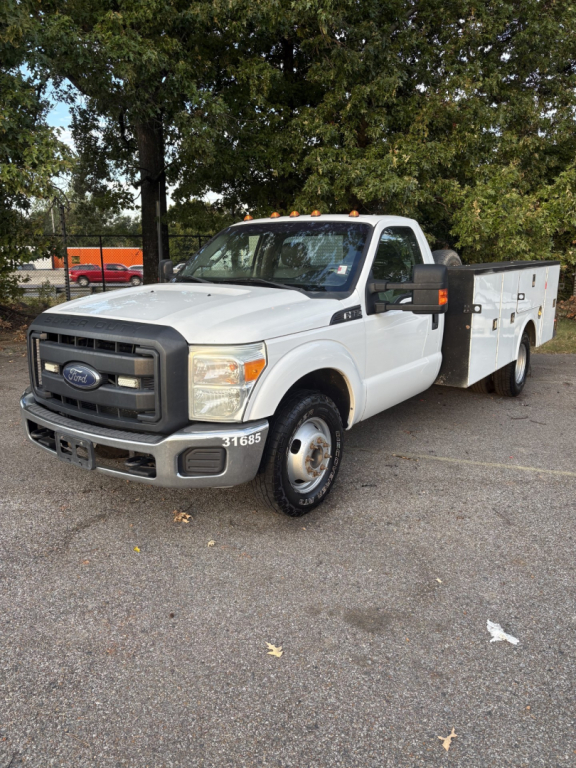 Ford F-350 cab and chassis white truck showing front grille and utility bed with compartments.