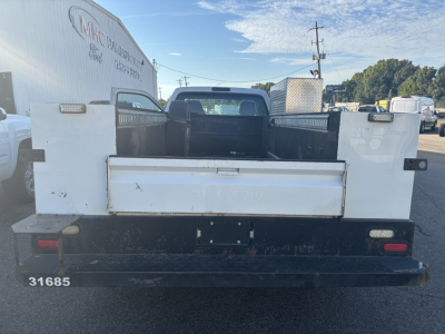 Back view of a white Ford F-350 cab and chassis pickup with cargo bed and tailgate, showing stock number 31685 and rear lights.