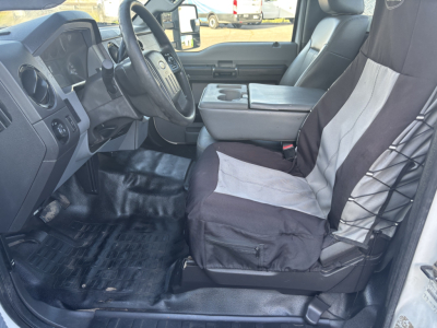 Ford F-350 cab and chassis interior showing driver's seat, steering wheel, center console armrest, and front passenger seat with two-tone fabric. Dashboard and floor mats visible.