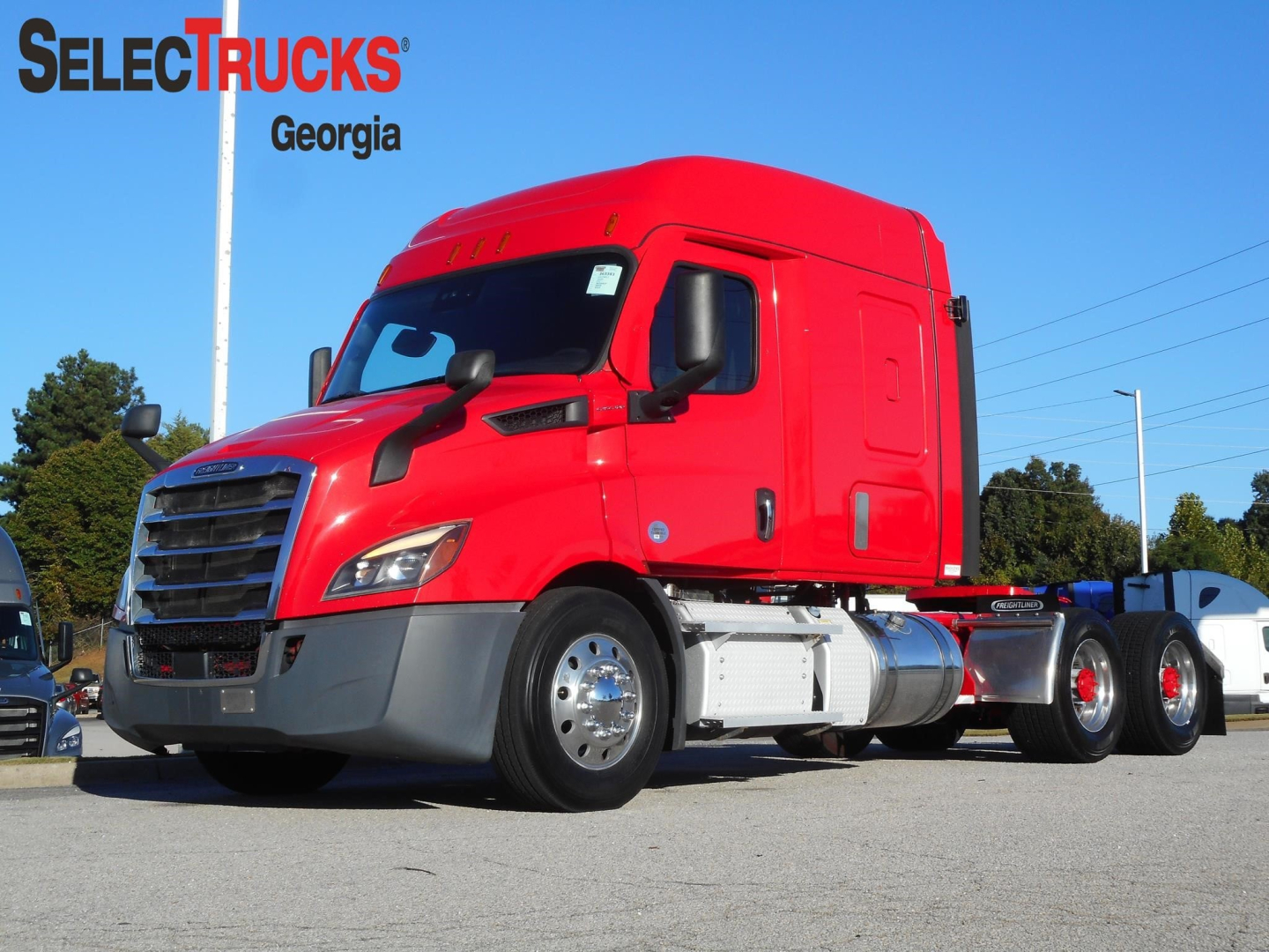 Red Freightliner Cascadia 116 sleeper tractor viewed from front-left, showing cab, chrome fuel tanks, and dual rear axles; SelectTrucks Georgia branding in top-left.