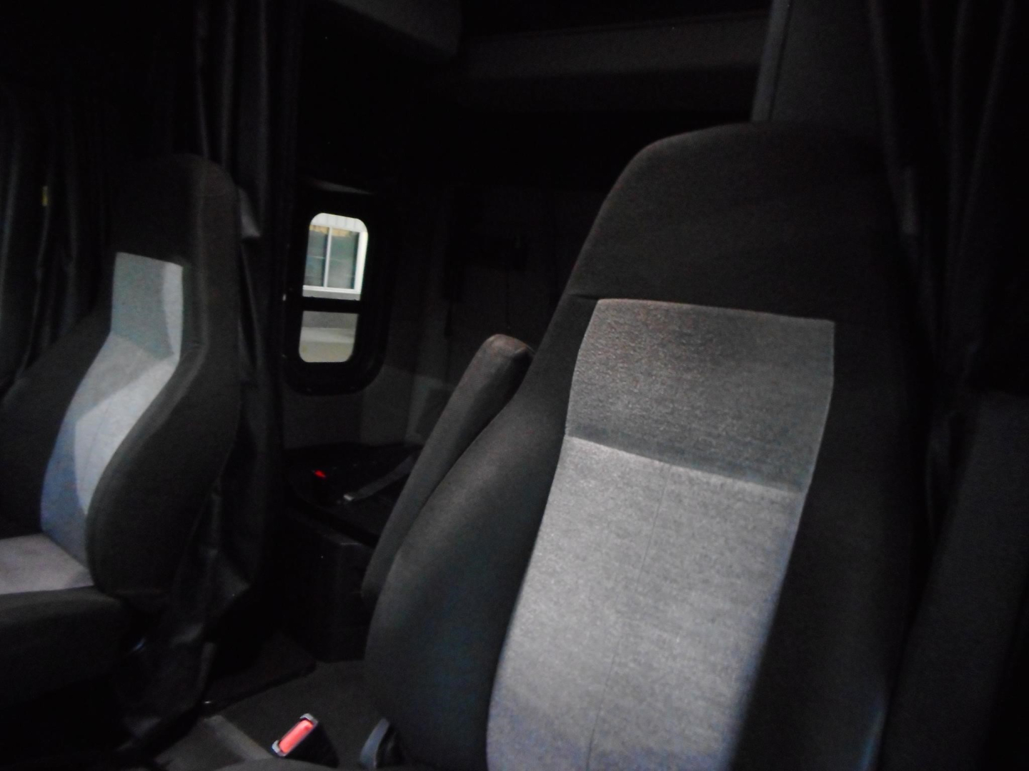 Freightliner Cascadia 116 interior seating view with grey and black upholstery, driver and passenger seats, cab area