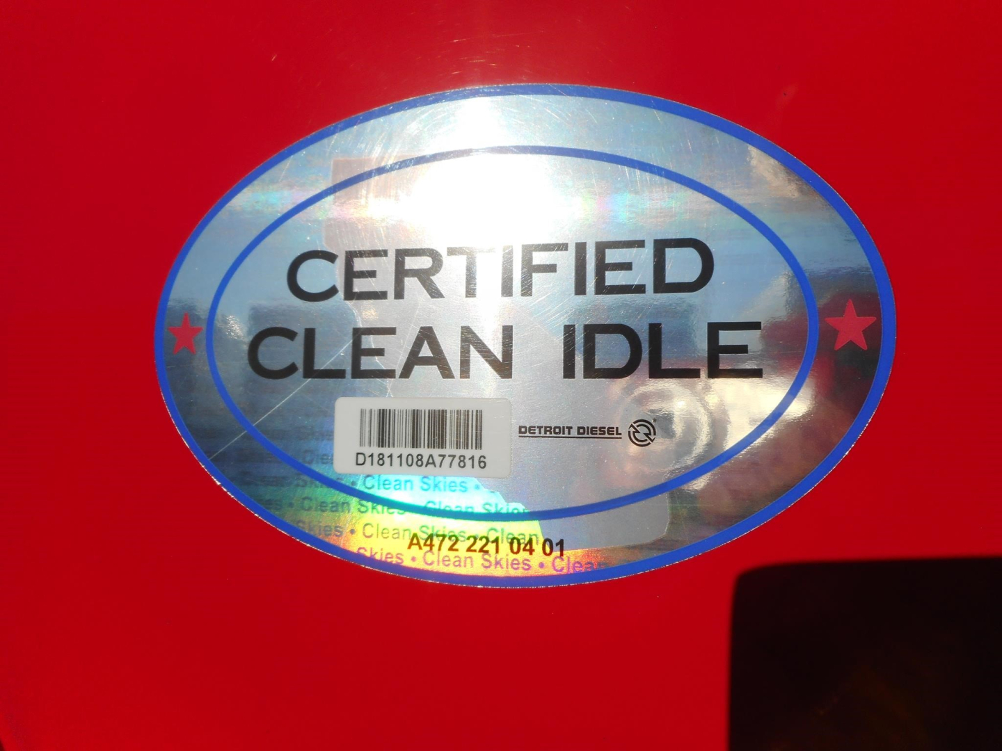 Certified Clean Idle sticker on red Freightliner Cascadia cab showing blue oval badge