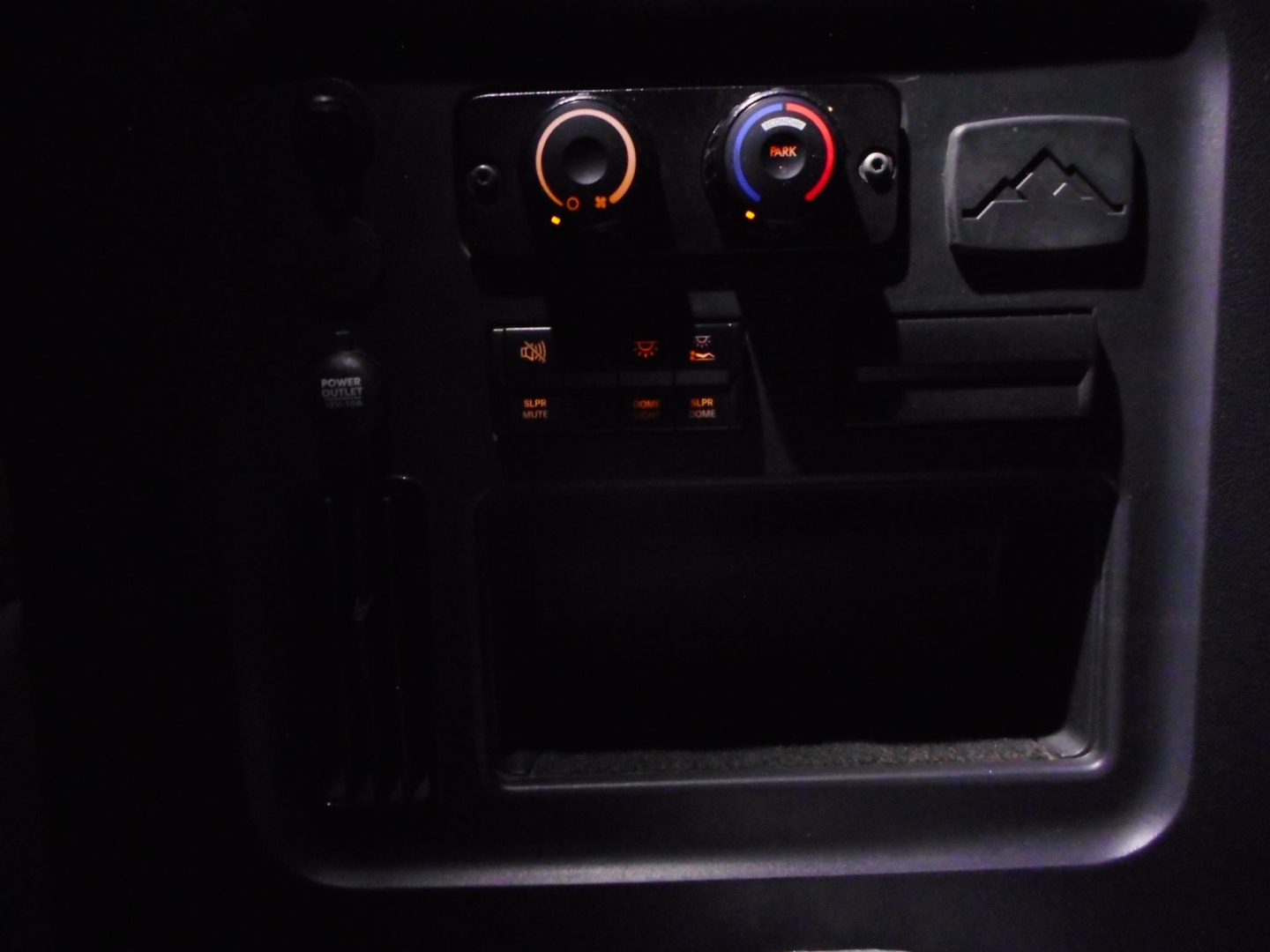 Freightliner Cascadia interior dash area showing climate control knobs and small electronic panel.
