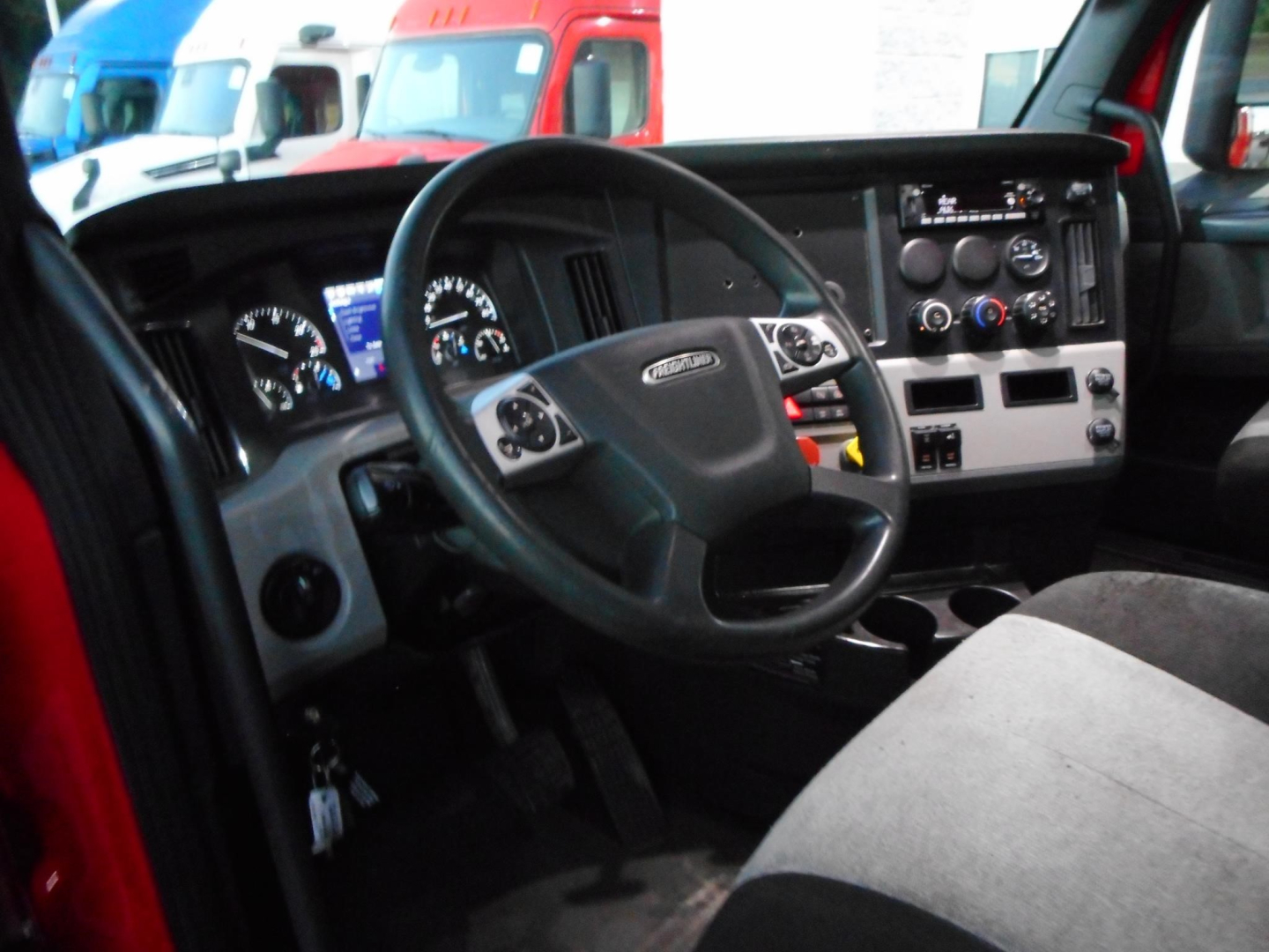 Truck cab interior of a 2020 Freightliner Cascadia 116 showing steering wheel, dashboard, and driver seat.